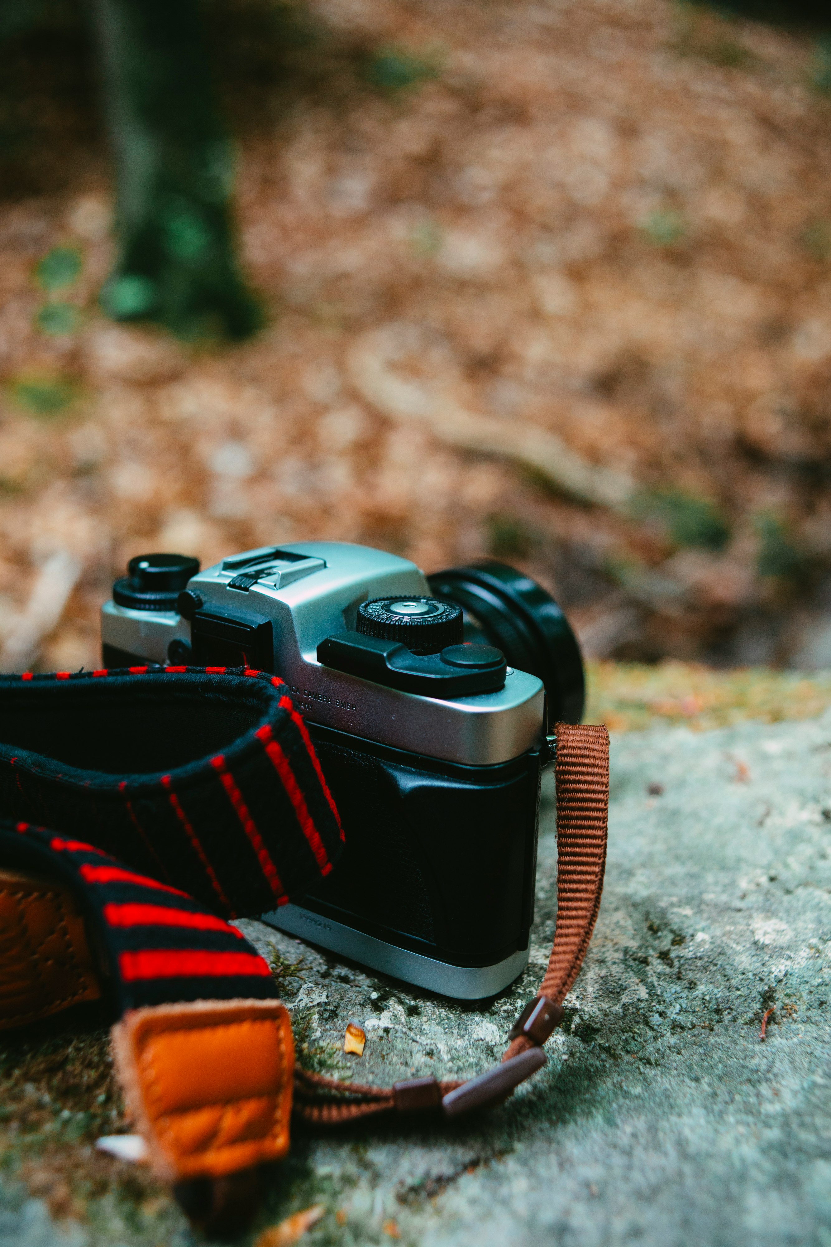 black and red dslr camera on ground